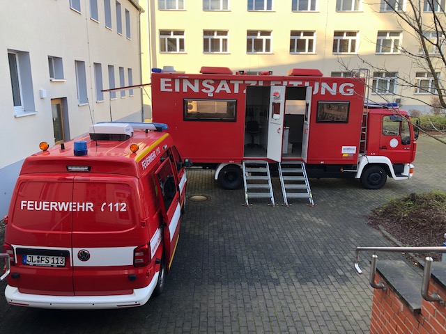 ein VW-Bus umgebaut zum Einsatzleitwagen und ein LKW umgebaut zur Einsatzleitung stehen in einem Innenhof