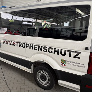 Einsatzleitwagen für den Katastrophenschutz von der Seite. Weißes Fahrzeug mit Schriftzug.