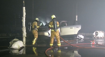 2 Feuerwehrmänner öffnen eine Motorhaube bei einem brandversuch an einem Fahrzeug