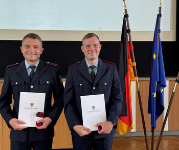 2 Personen mit Zeugnissen von Fahnen