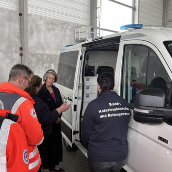 Mitarbeiter Rettungsdienstorganisation erklären und diskutieren mit der Innenministerin