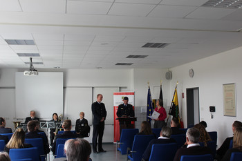 Ministerin übergibt Schriftstück an Brandoberinspektor.