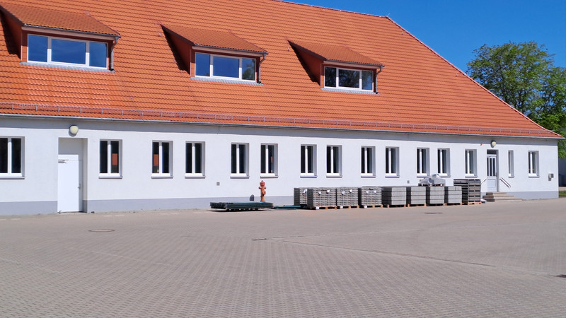 vor der Sporthalle des IBK lagern Baumaterialien