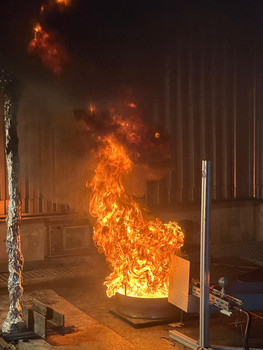 Flammender Abbrand einer Flüssigkeit in einer Brandwanne in einem Versuchsraum.