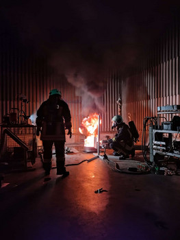Brennen einer Flüssigkeit in einer Brandwanne. Zwei Wissenschaftler beobachten den Prozess.  
